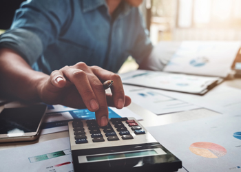 Man with calculator looking at financial statements